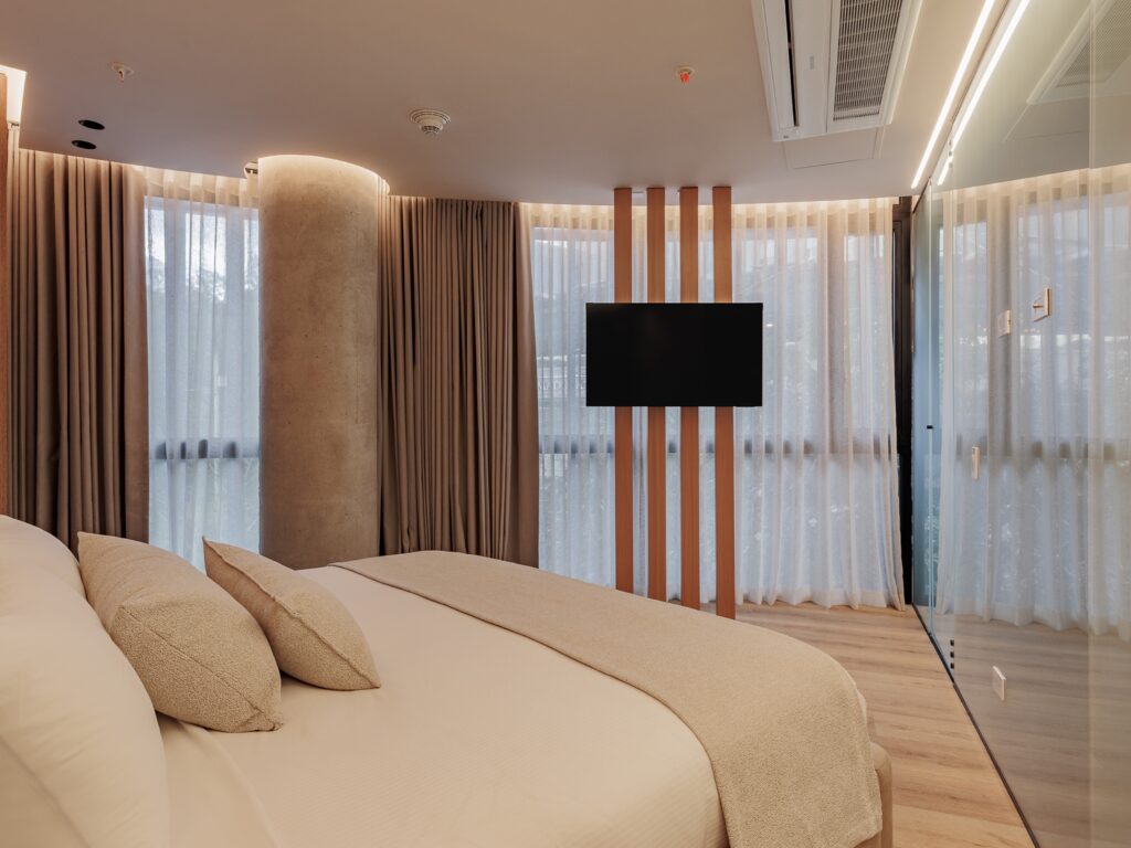 Suite Superior — dormitorio con TV y tabiques terracota